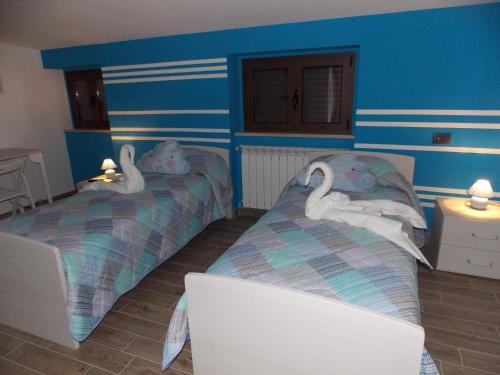 two beds in a room with swans on them at Vico 59 in Ortona