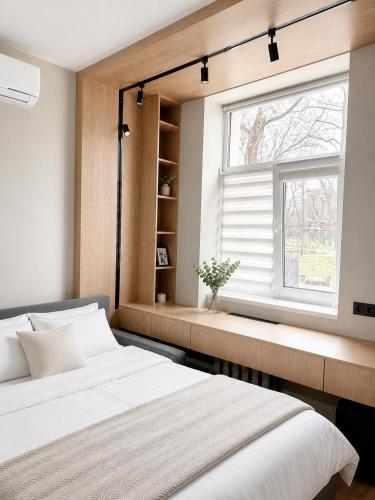 a bedroom with a bed and a window at Cathedral Park Modern studio in Chişinău