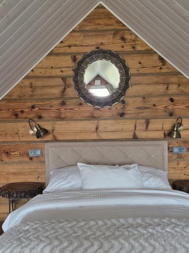 a bedroom with a bed with a wooden wall at Noclegi Panorama - Domek RUSTIC in Ustrzyki Dolne