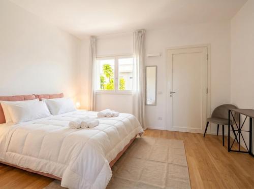 a white bedroom with a large bed and a window at Dimora Anna - Exclusive Sea Loft in Bari