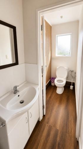 a bathroom with a white sink and a toilet at The Crossing Lodge in National Park