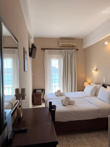a hotel room with two beds and a table at Hotel Lemnos in Myrina