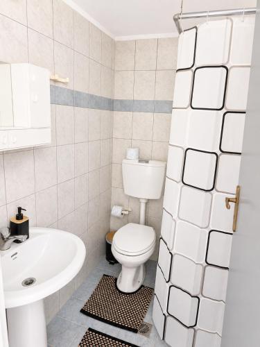 a white bathroom with a toilet and a sink at University Apartment in Heraklio