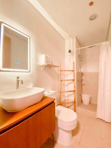 a white bathroom with a sink and a toilet at Hiraya Luna in Manila