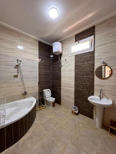 a bathroom with a tub and a toilet and a sink at Ira Hostel in Dahab