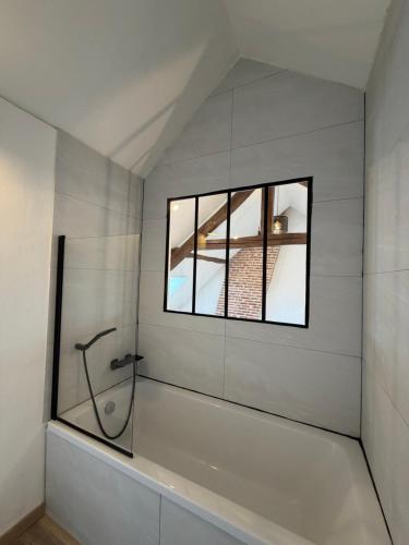 a white bathroom with a shower and a window at Maison de bourg de village in Dame-Marie-les-Bois
