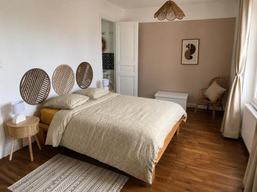 a bedroom with a bed and a table and chairs at Entre Rails & Rives in Montbard