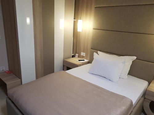a bedroom with a bed with a white pillow at Hotel Crystal Light in Niš