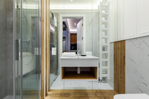 a bathroom with a white sink and a shower at Amber Elite Apartments in Stegna
