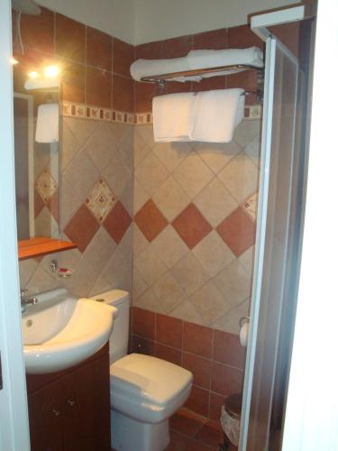 a small bathroom with a toilet and a sink at Guesthouse Aktaion in Afissos