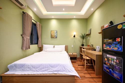 a bedroom with a bed and a desk and a television at Harmony Stay - Ben Thanh Market in Ho Chi Minh City