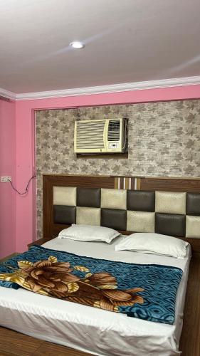 a bedroom with a large bed with a air conditioner at BS Residency in Dehradun