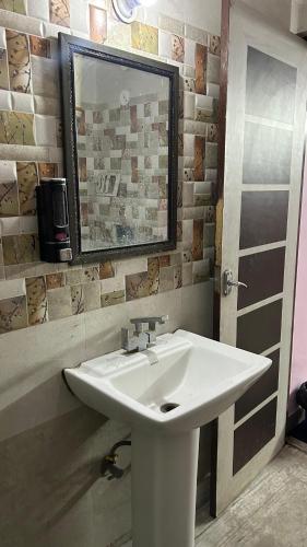 a white sink in a bathroom with a mirror at BS Residency in Dehradun