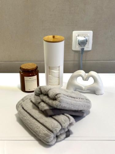 a bathroom counter with a towel and a soap dispenser at Legend Suites Bitola in Bitola