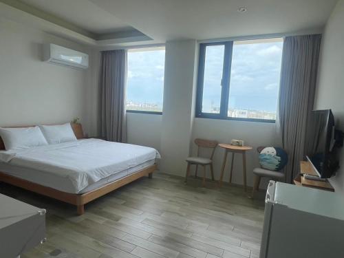 a bedroom with a bed and a desk with a television at Sea Quilt Bed and Breakfast in Xujiacun