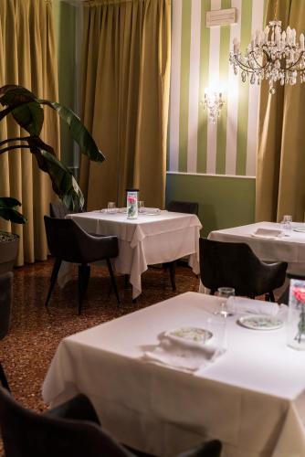 a dining room with two tables with white tablecloths at Locanda Confini in Dolo