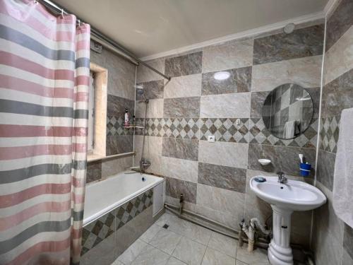 a bathroom with a sink and a bath tub and a sink at AJO Guesthouse in Naryn