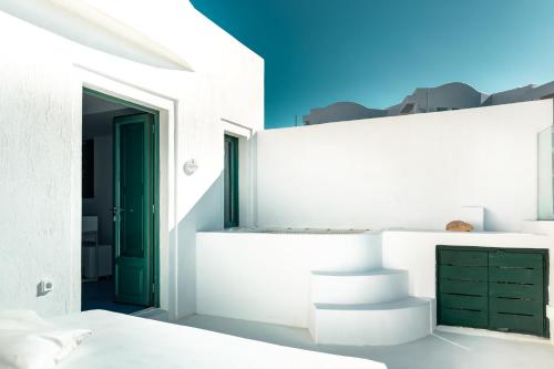 a bedroom with white walls and a green door at Epic View Suites in Akrotiri