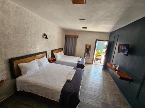 a hotel room with two beds and a balcony at Villa Acuario in Tapachula