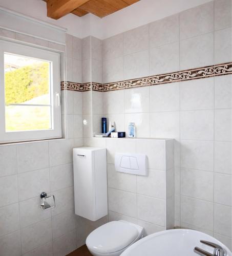 a white bathroom with a toilet and a sink at Il Nido in Agra
