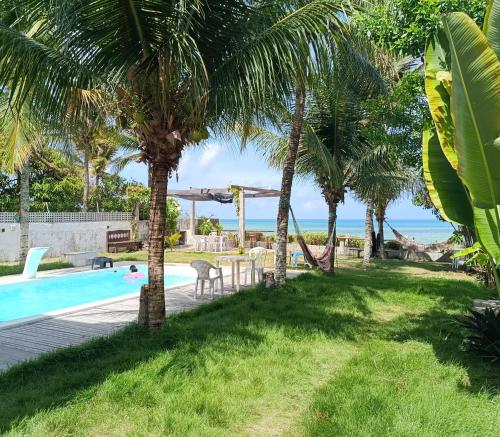 a resort with a pool and palm trees at Suite Quadrupla Terreo Oceazul in Conde