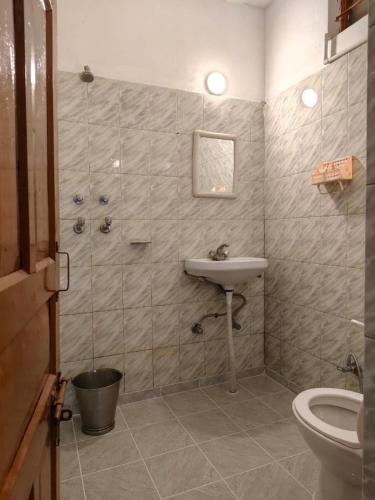 a bathroom with a shower and a sink and a toilet at Aranya Tara in Bhīm Tāl