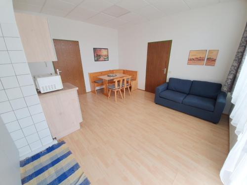 a living room with a blue couch and a table at Grössingblick in Zeltweg