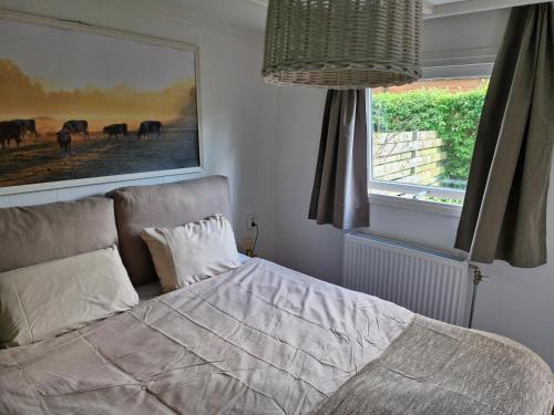 a bedroom with a bed and a picture of horses at Nieuw chalet in Nunspeet in Nunspeet