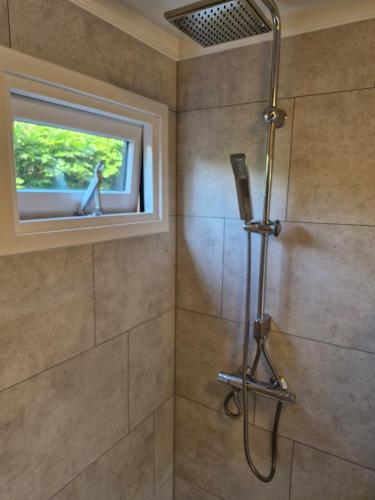 a bathroom with a shower with a window at Nieuw chalet in Nunspeet in Nunspeet