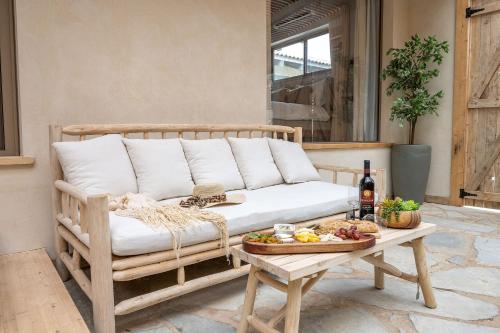 a couch on a patio with a table with a plate of food at סוויטת דרים רויאל - סוויטה חלומית עם אמבט ספא מפנק ונוף מדהים in ‘Ein Ya‘aqov