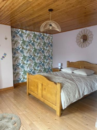 a bedroom with a large bed with a wooden headboard at La Salamandre in Valprivas