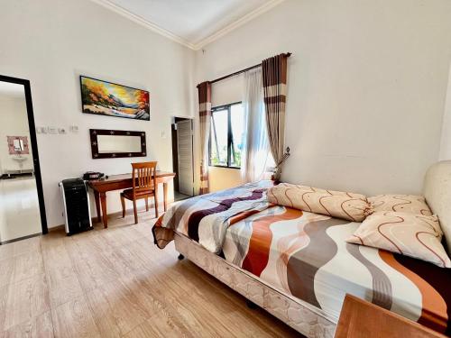 a bedroom with a bed and a desk in it at MP Villa Tirta Sevil S3 Malang in Mantaak