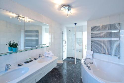 a bathroom with a tub and a sink and a toilet at Hotel Penz West in Innsbruck