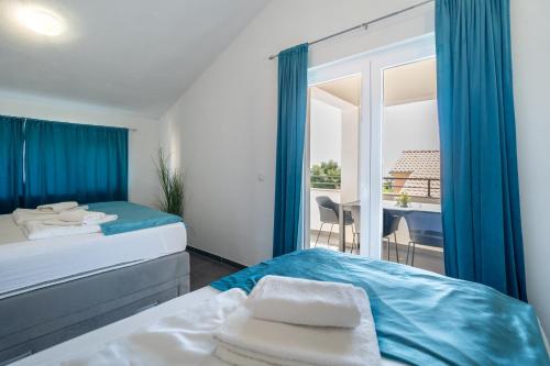 a hotel room with two beds and a balcony at Holiday Apartments Amarilis in Pakoštane