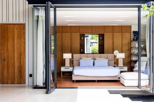 a bedroom with a bed and a glass wall at Botanica Foresta Luxury Villa Phuket in Phuket