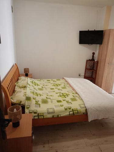 a bedroom with a bed with a green comforter at Studio Apartman GRACIJA in Herceg-Novi