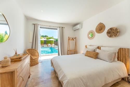 a bedroom with a bed and a pool at Le Cabanon de Val in Gassin