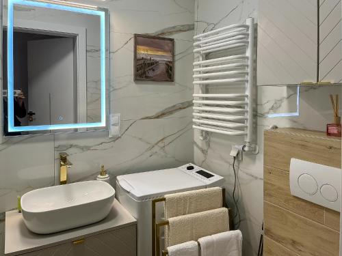 a white bathroom with a sink and a mirror at Nowy Dwór Mazowiecki Chic Studio by BookingHost in Nowy Dwór Mazowiecki