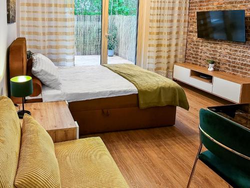 a bedroom with a bed and a tv and a couch at Nowy Dwór Mazowiecki Chic Studio by BookingHost in Nowy Dwór Mazowiecki