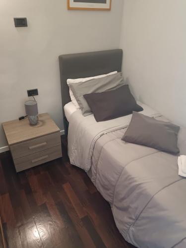 a bedroom with two beds and a night stand at Casa vacanza Pescasseroli in Pescasseroli