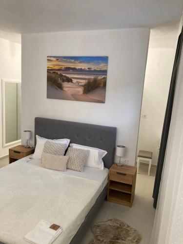 a bedroom with a large white bed with two tables at KEFI House in Pondolívadhon