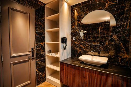 a bathroom with a sink and a mirror at Oak Villa in Dharampur