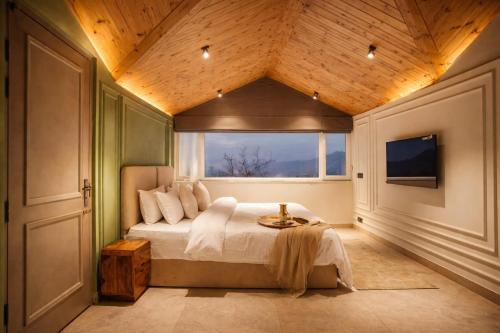 a bedroom with a large bed and a window at Oak Villa in Dharampur