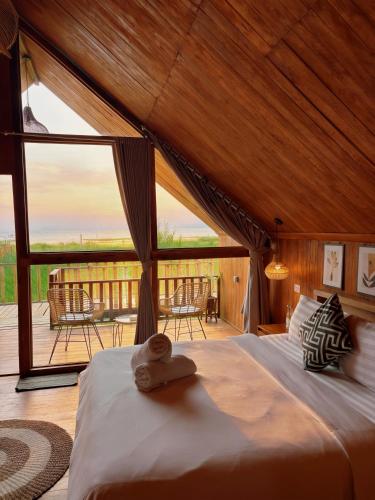 a bedroom with a bed and a large window at Dynasty Glamping Bedugul in Bedugul