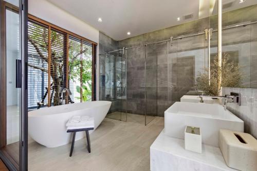 a bathroom with a large tub and a sink at Botanica Foresta Luxury Villa Phuket in Phuket