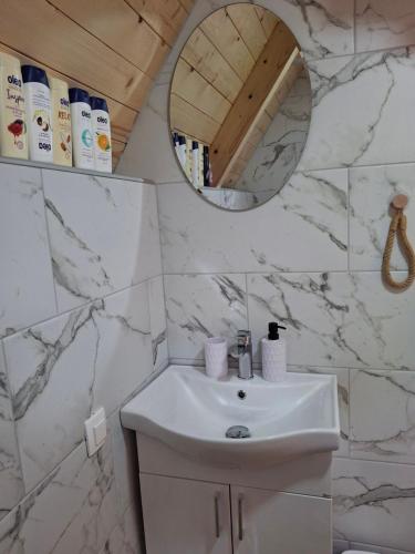 a white bathroom with a sink and a mirror at Lake house Andrej & Andrea in Kuside