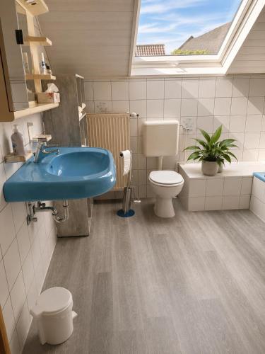 a bathroom with a blue sink and a toilet at Monteurzimmer-Graf in Nidda