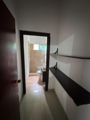 a bathroom with a toilet and a stairway leading to a bathroom with a door at Casa 007 in Carmen de Apicalá
