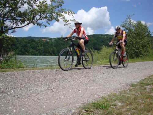 due persone che vanno in bicicletta su una strada sterrata vicino a un lago di Ferienwohnung Mostecky a Ferlach