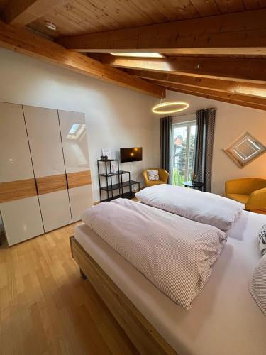 a bedroom with two beds and a living room at Landhaus am Bach in Sulzberg